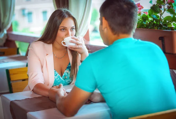 若い幸せカップル カフェでテーブルに座ってコーヒーを飲む — ストック写真