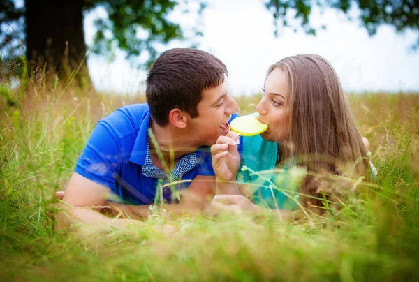 Romântico Jovem Casal Com Doces Deitado Grama Verde Parque — Fotografia de Stock