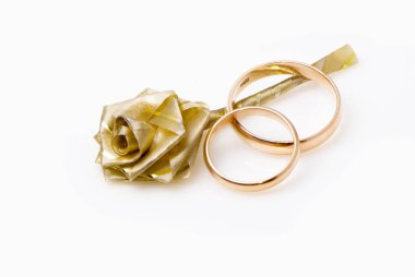 iki altın alyans ve kağıt gül beyaz izole