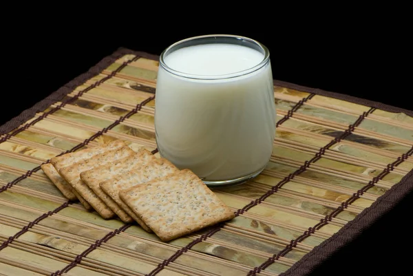 ガラスのミルクと黒の表面にクッキー — ストック写真