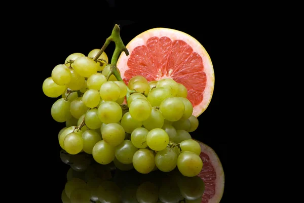 反映黑色表面的葡萄和葡萄柚 — 图库照片