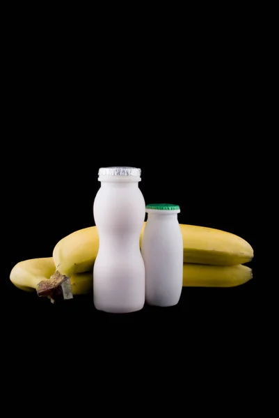 Ripe Bananas Plastic Bottles Yogurt Black Background — Stock Photo, Image