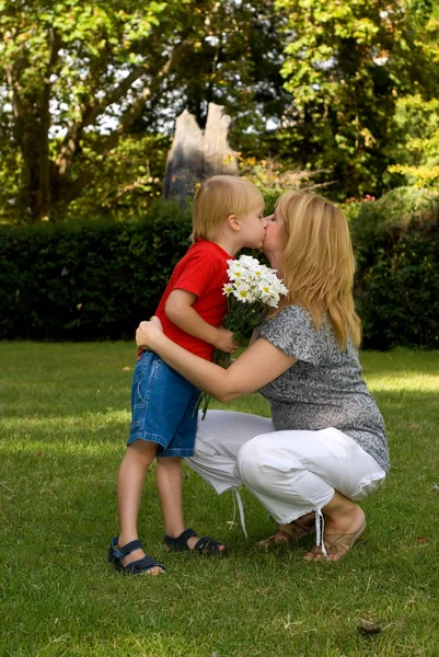 Urocza Syn Prezentując Bukiet Kwiatów Matki Parku — Zdjęcie stockowe