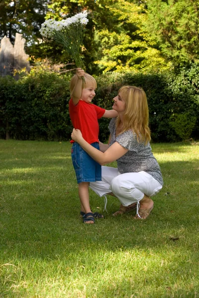 Gelukkig Moeder Knuffelen Zoon Hij Houdt Boeket Bloemen — Stockfoto