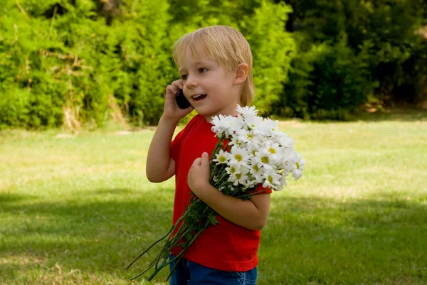 Niño Feliz Sosteniendo Flores Blancas Hablando Teléfono Pie Sobre Fondo —  Fotos de Stock