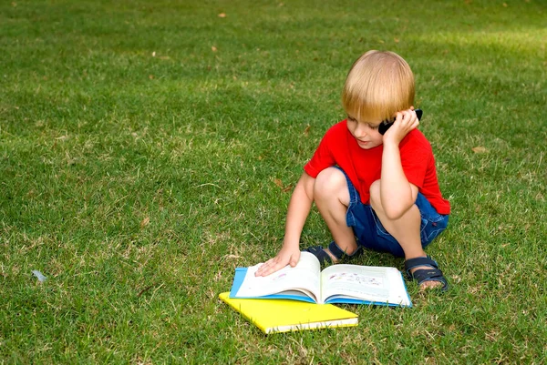 Söt Liten Pojke Sitter Grönt Gräs Med Böcker Och Pratar — Stockfoto