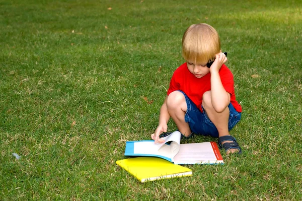 Sevimli Küçük Çocuk Kitapları Ile Yeşil Çimenlerin Üzerinde Oturan Cep — Stok fotoğraf