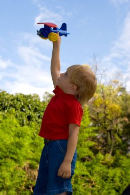 yeşil park düzlemde renk oynamaktan mutlu küçük çocuk