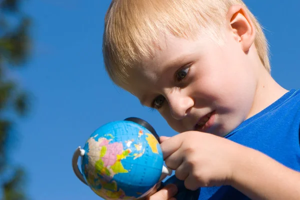 Милий Маленький Хлопчик Тримає Глобус Дивиться Збільшувальним Склом Фоні Блакитного — стокове фото