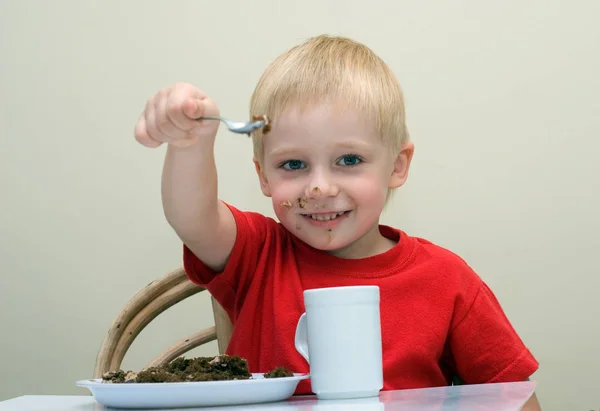 Šťastný Chlapec Jíst Domácí Koláč Sedí Stolu Lžící Tea Cup — Stock fotografie
