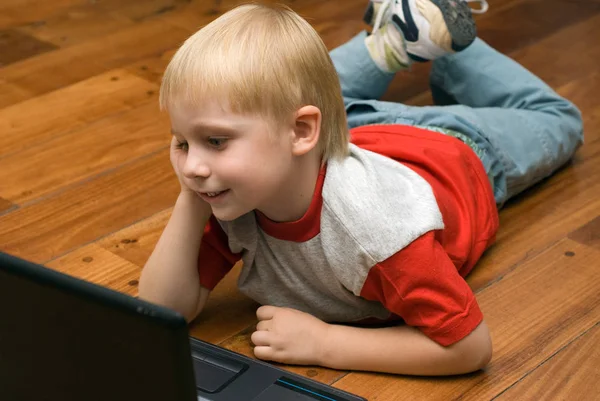 Porträtt Söt Blond Pojke Liggande Trägolv Med Laptop — Stockfoto