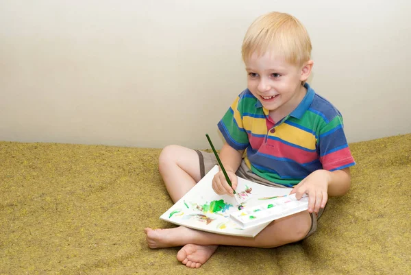 坐在沙发上 用画笔画画的快乐小男孩肖像 — 图库照片