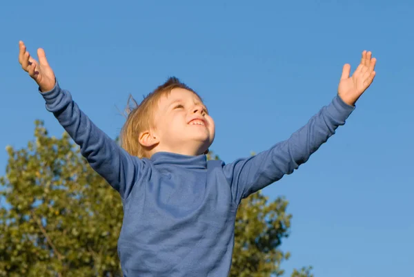 Kleiner Junge Mit Offenen Händen Auf Blauem Himmel — Stockfoto