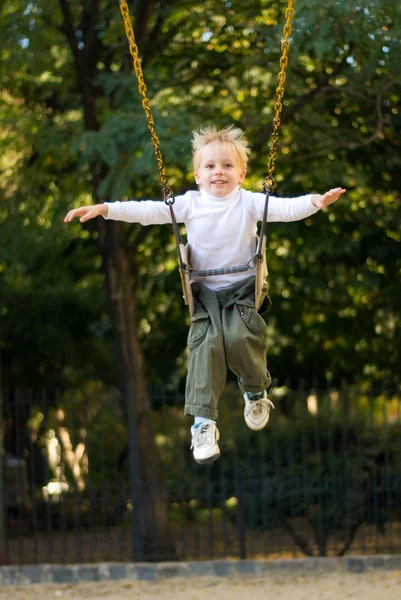 可爱的金发男孩在公园荡秋千的乐趣 — 图库照片