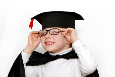 mezun olan şapka, siyah pelerin ve gözlük gülümseyen küçük çocuk