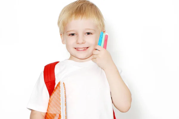 快乐的小男孩的肖像与背包 书和彩色铅笔摆在白色背景与复制空间的孤立 — 图库照片