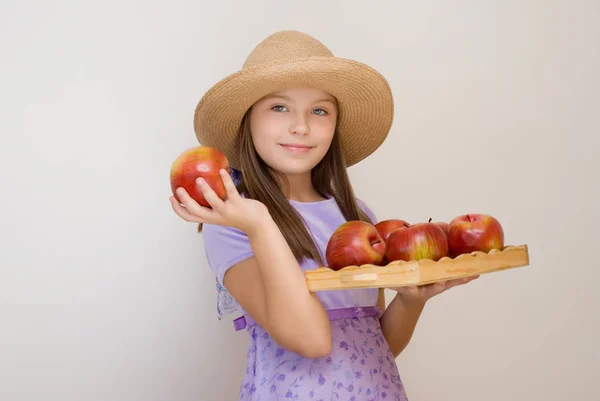 Μικρό Κορίτσι Που Φοράει Ψάθινο Καπέλο Κρατά Θήκη Κόκκινα Μήλα — Φωτογραφία Αρχείου