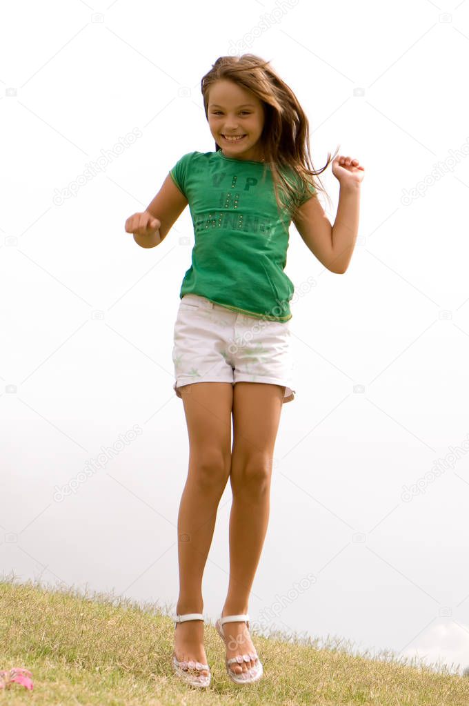 full length portrait of happy girl jumping on foggy background