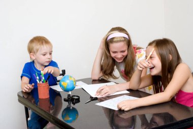 happy children studying at table at home clipart