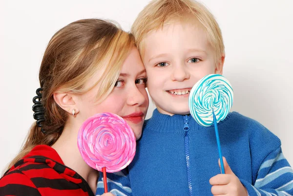 年轻女孩和小男孩的演播室画像举行颜色棒糖 — 图库照片