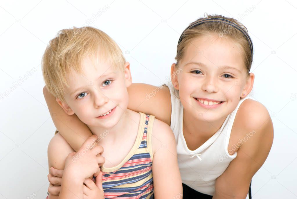 smiling adorable sister and brother looking at camera isolated on white