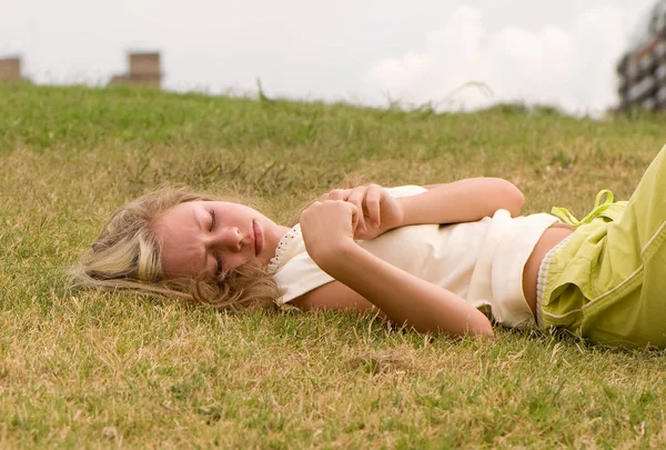 目を閉じて横になっている緑の草 完全な長さの十代の少女 — ストック写真