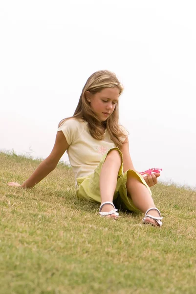 Promyšlené Dospívající Dívka Drží Růžový Květ Sedí Zelené Trávě — Stock fotografie