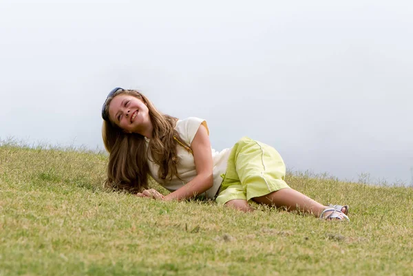 緑の草の完全な長さで横になっている笑顔のサングラスをかけた美しい十代の少女 — ストック写真