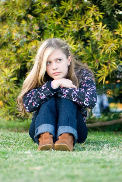 可爱的十几岁女孩坐在绿色的草地上花园 — 图库照片