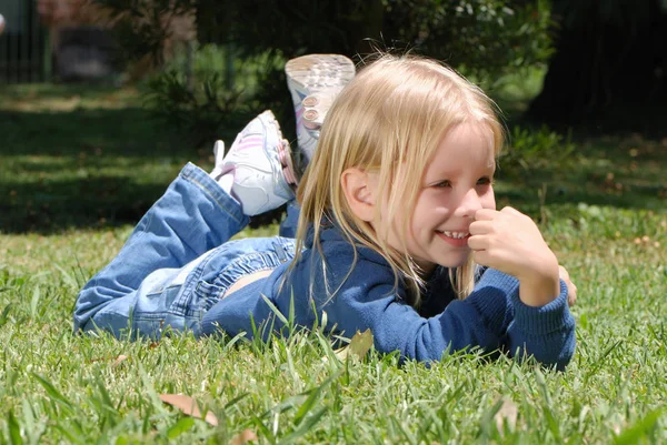 Parkta Çimenler Üzerinde Yatan Sevimli Küçük Kız Portresi — Stok fotoğraf