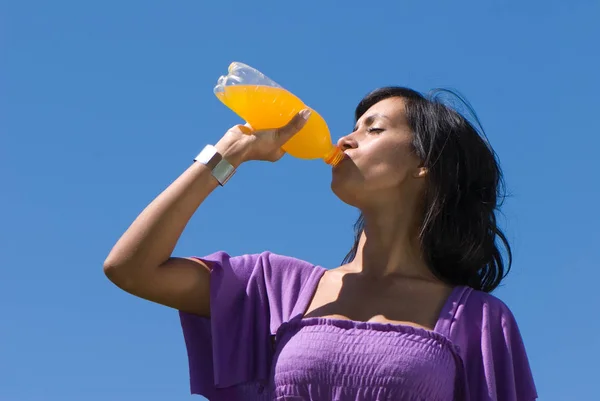 Hermosa Joven Bebiendo Jugo Naranja Frente Del Cielo Azul — Foto de Stock