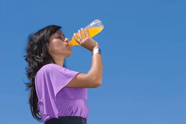 Mooie Jonge Vrouw Drinken Sinaasappelsap Voorkant Van Blue Sky — Stockfoto