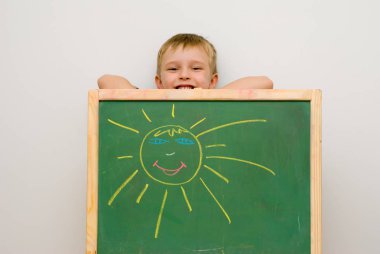 beyaz duvar önünde tebeşir ile sevimli küçük çocuk