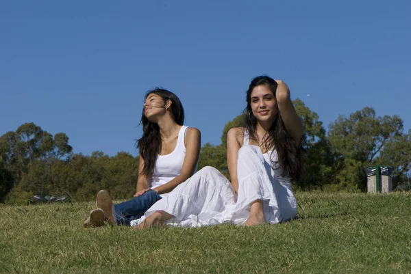 公園の緑の草の上で一緒に時間を過ごす美しい若い女性 — ストック写真