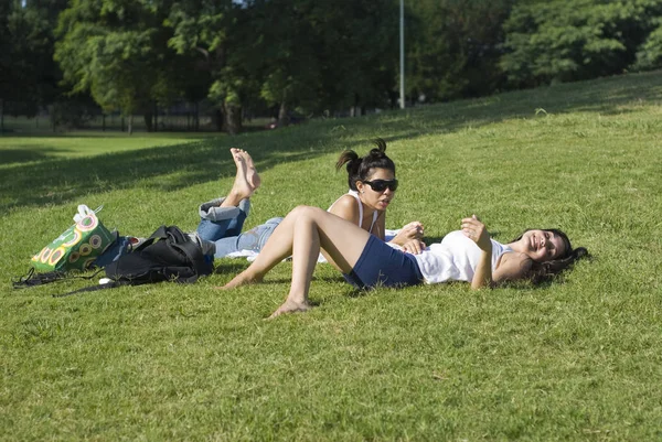 Güzel Genç Kadınlar Parkta Yeşil Çim Üzerinde Birlikte Vakit Geçirmek — Stok fotoğraf