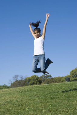 güzel genç kadın parkta yeşil çayır üzerinde rahatlatıcı