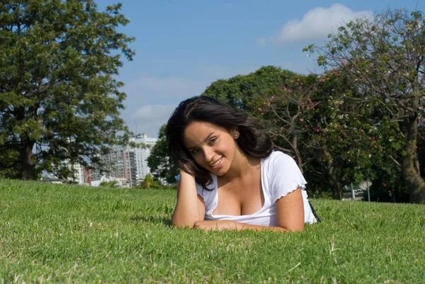 美丽的年轻女子放松在绿草在公园 — 图库照片