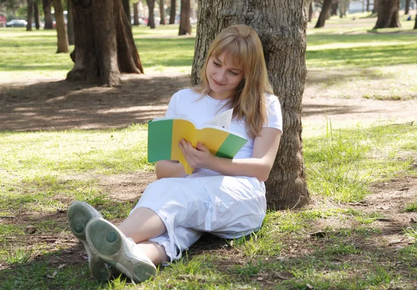 美しい若い女性読書本で公園 — ストック写真