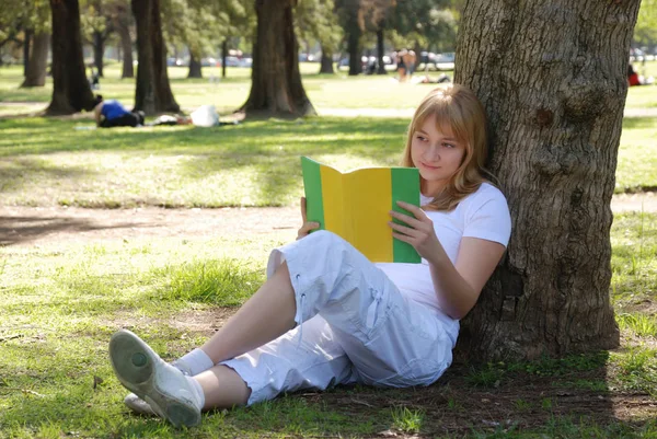 美しい若い女性読書本で公園 — ストック写真