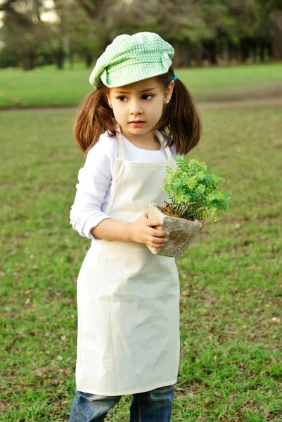 公園で植木鉢を持つ愛らしい小さな女の子の肖像画 — ストック写真