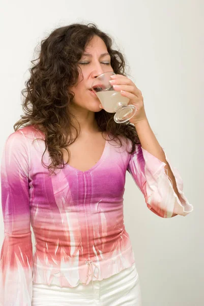 美丽的女人的肖像与玻璃饮料在白色前 — 图库照片