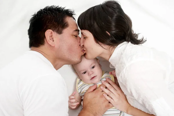 Baby Met Ouders Liggend Een Bed Een Witte Achtergrond — Stockfoto