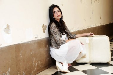 Eski bir bavulu olan güzel bir kadın.