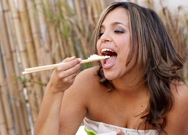 美丽的女人吃米饭用棍子 — 图库照片