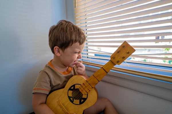 Niño Feliz Con Una Guitarra Cerca Ventana — Foto de Stock