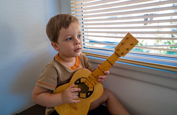 Niño Feliz Con Una Guitarra Cerca Ventana —  Fotos de Stock