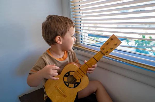 Niño Feliz Con Una Guitarra Cerca Ventana —  Fotos de Stock