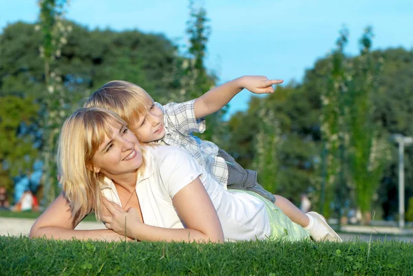 母亲和儿子在绿色草地上玩 — 图库照片