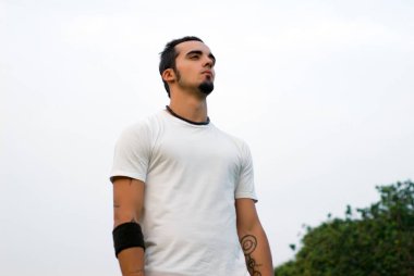 Portrait of a Hispanic guy against the sky