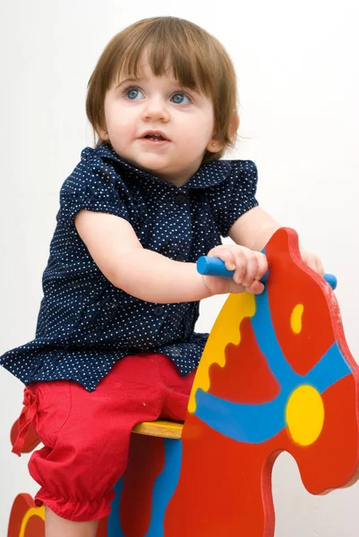 Portret Van Kleine Meisje Paardrijden Houten Paard Witte Achtergrond — Stockfoto